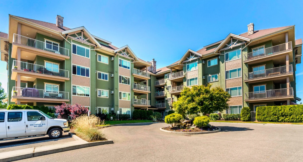 Wildwood III — multi-story residential building with autumn trees and street parking